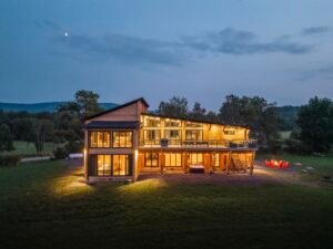 Ulula — великий модульний готель із бруса з багаторівневими терасами та панорамним освітленням у вечірній час